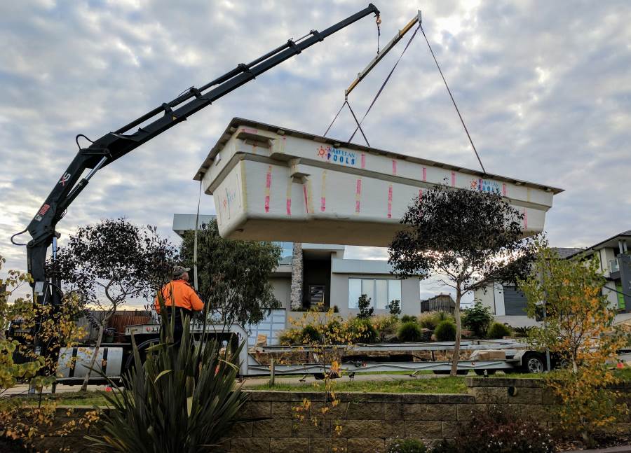 Pool shell being maneuvered into place by the operator